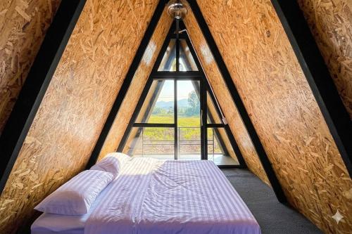 a bed in a room with a window at Ban Tew Kao in Ban Nong Chaeng