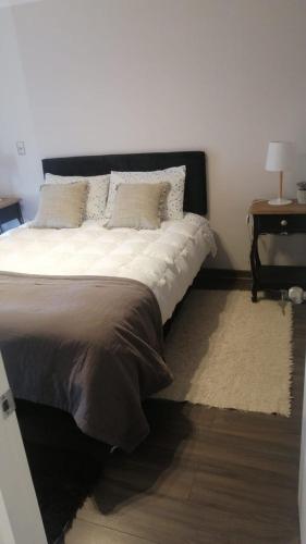 a bedroom with a large bed with a night stand at privilegio apart in Los Ángeles