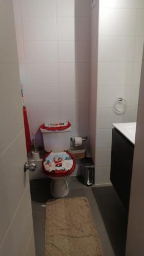 a bathroom with a toilet with a red lid at privilegio apart in Los Ángeles
