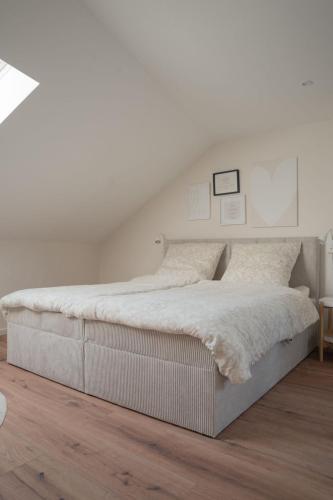 a white bedroom with a large white bed at Altstadt Suite Bitburg in Bitburg