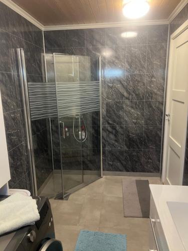 a bathroom with a shower with a glass door at Vadlåsveien 4 in Egersund