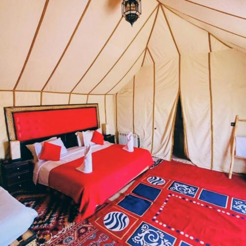 a bedroom with a bed in a tent at Sunrise Dunes Luxury Camp in Merzouga