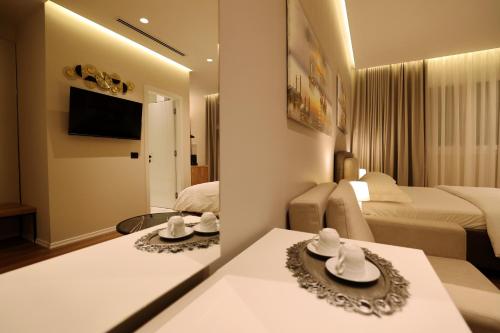 a hotel room with two tables and two beds at Theatro Hotel Apartaments Tirana in Tirana