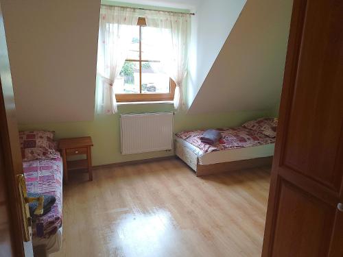 a small room with two beds and a window at Zamkowa in Puck