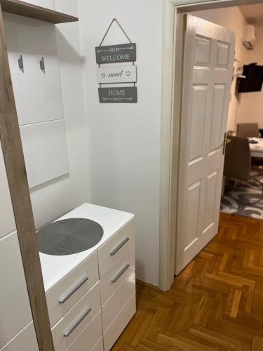 a white kitchen with a sink and a door at Apartman B&S Apatin in Apatin