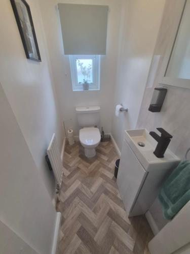 a small bathroom with a toilet and a sink at Highwood mews in Cleethorpes