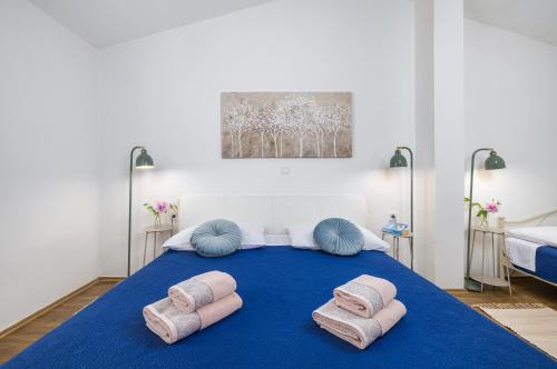 a bedroom with a blue bed with pillows on it at Funcic Apartments 1 app in Pula