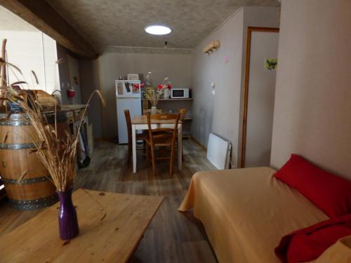 a living room with a table and a room with a kitchen at Chambre prairie in La Roche-sur-Yon