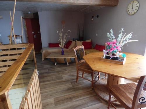 a living room with a table and a couch at Chambre prairie in La Roche-sur-Yon