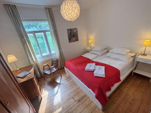a bedroom with a large bed with a red blanket at Wienerwaldhof in Irenental
