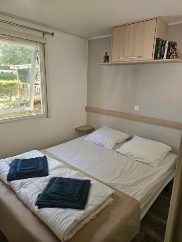 a bedroom with two beds with towels on them at Camping Mobil Home 6 Pers Rivage des Landes Piscine Landes in Aureilhan