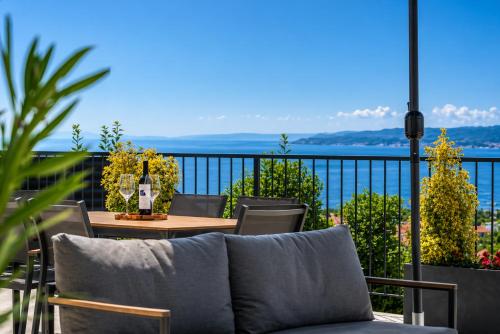 a table and chairs on a balcony with a view of the ocean at Apartments Alba Chiara in Kastav