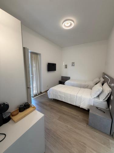 a white bedroom with a bed and a television at Tesorella guest house in Cassano dʼAdda