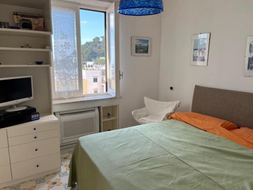 a bedroom with a bed and a tv and a window at Borgo Antico di Capri in Capri