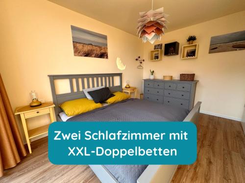 a bedroom with a bed with yellow pillows and a dresser at Meerglück am Beltblick Fehmarn - FeWo mit Sauna, Blick auf Ostsee und Leuchtturm, nur 150 m zum Meer in Fehmarn