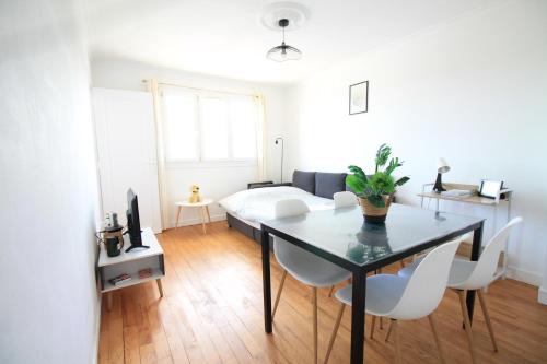 a living room with a table and a bed at La Colline - Pont-Hébert - com - Grand Parking gratuit, De 1 à 4 personnes, Tout équipé, Netflix, Amazon Prime Gratuits et Illimités, Matelas Emma, Lave Linge, Vue sur la Vallée, RDC in Pont-Hébert