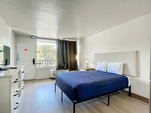 a bedroom with a bed with a blue comforter at Stayable Davenport in Davenport