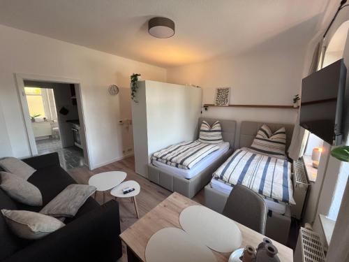 a living room with a couch and a bed at Gästewohnung Mable in Greiz