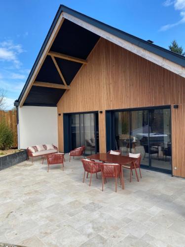 a patio with a table and chairs and a building at L'Instant Cottage, Chic et Spa près d'Amboise in Saint-Règle
