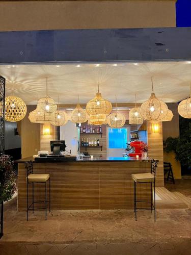 a bar in a restaurant with chandeliers at Weedan Hotel & Spa Marrakech in Oulad Snaguia
