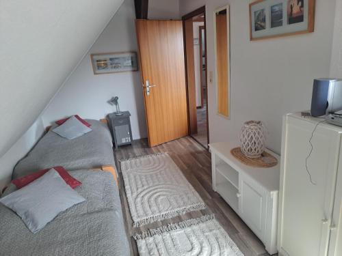 a bedroom with two beds and a hallway with a door at Haus Dorfschmiede, Wohnung Anker in Alkersum