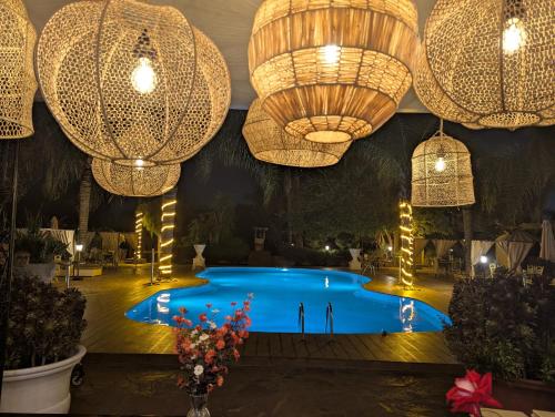 a pool in a room with chandaliers and lights at Weedan Hotel & Spa Marrakech in Oulad Snaguia