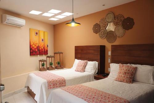 a bedroom with two beds with white sheets at Casa La Vikina in Guanajuato