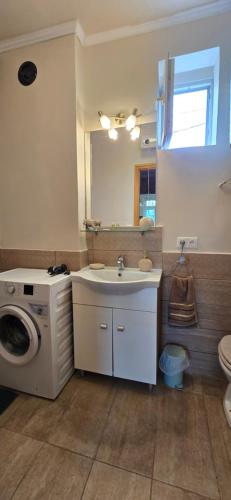 a bathroom with a sink and a washing machine at History Tornyos Apartman in Balatonfüred
