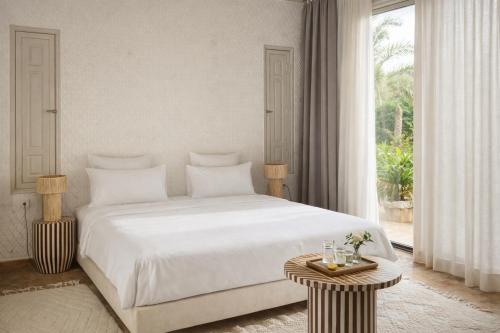 a bedroom with a white bed and a large window at Riad Jawad & Spa in Marrakesh