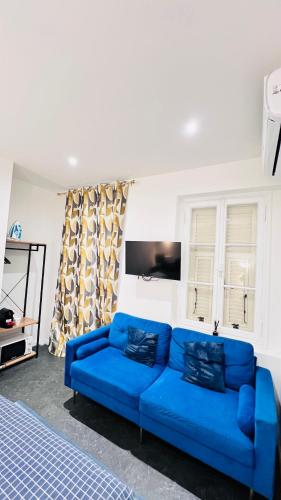 a blue couch in a living room with a tv at A 100m de Monaco, café de paris, plage in Beausoleil