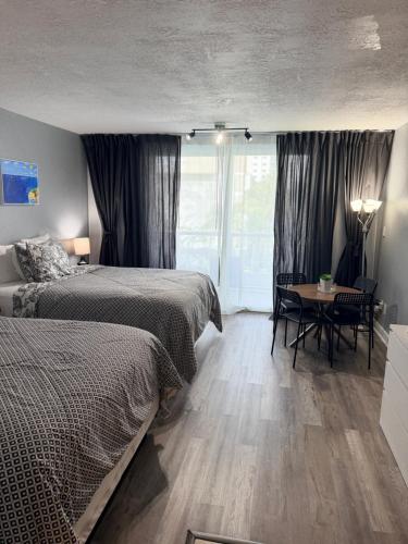 a bedroom with two beds and a table and a window at Miami Sunny Isles Beach Ocean Front Resort Condo with balcony Pool, Beach,Gym,Valet Parking in Sunny Isles Beach
