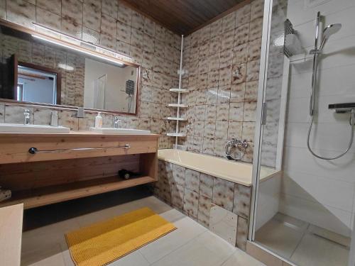 a bathroom with a shower and a tub and a sink at Haus am Ring in Spielberg