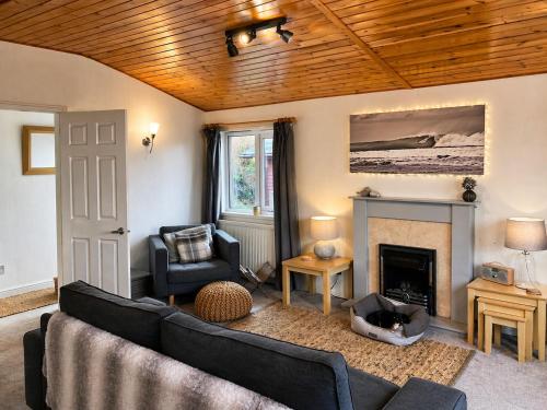 a living room with a couch and a fireplace at Beautiful Lodge Retreat - 3 Bedrooms - Sleeps 6 in West Down