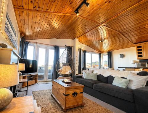 a living room with a couch and a tv at Beautiful Lodge Retreat - 3 Bedrooms - Sleeps 6 in West Down