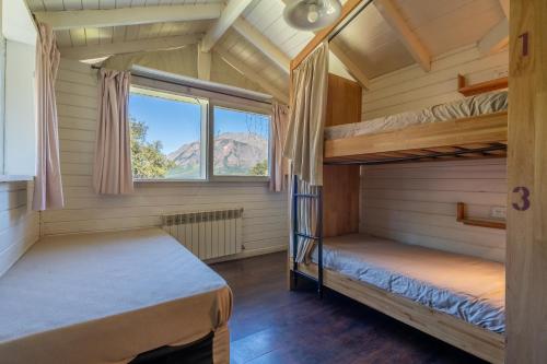two bunk beds in a room with a window at INDÓMITO HOSTEL in San Carlos de Bariloche