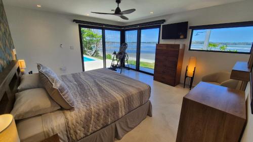 a bedroom with a bed and a view of the ocean at Stunning seaside villa with pool and jacuzzi in Boca Chica