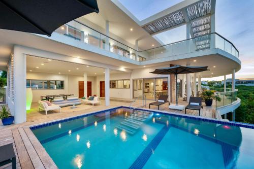 a house with a swimming pool and a patio at Skyline Villas - Villa Skyline with stunning Ocean View in Providenciales