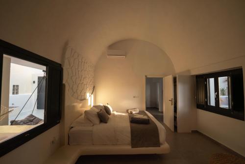 a bedroom with a bed and a large window at Rosaviglia Luxury Villa - an Oia Private Hideaway in Oia