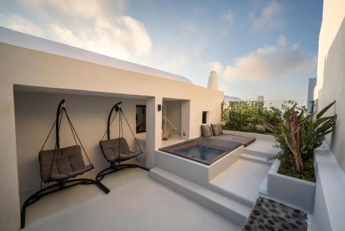 a balcony with a hot tub and two chairs at Rosaviglia Luxury Villa - an Oia Private Hideaway in Oia