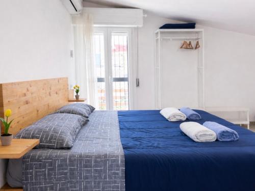 a bedroom with a blue bed with two pillows at Thalassa Holiday Home with Terrace near the Sea - Anzio in Anzio