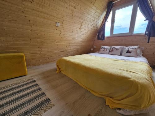 a bedroom with a bed in a wooden wall at Elioan Cozy A-Frame in Mărăcineni