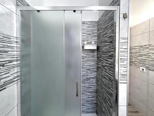 a shower with a glass door in a bathroom at Thalassa Holiday Home with Terrace near the Sea - Anzio in Anzio