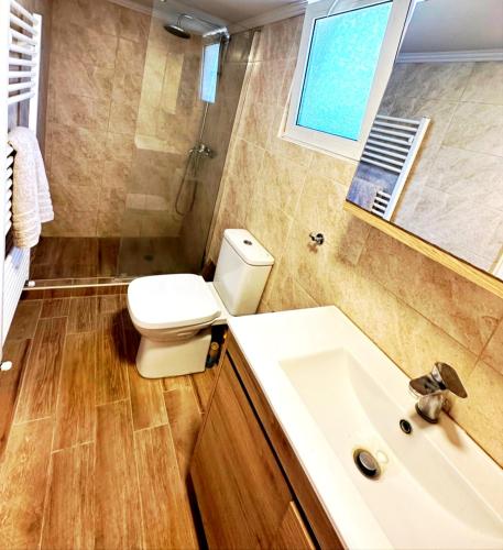 a bathroom with a toilet and a sink at Bougainvillea Retreat above Faliraki in Kalithies