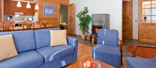 a living room with a blue couch and a fireplace at Kelotie, Saariselkä, only week 24 available in Saariselka