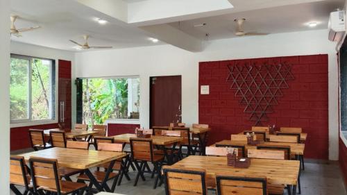 a dining room with wooden tables and chairs at Lotus Leaf Resort, Murud in Murūd