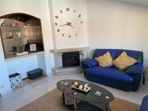 a living room with a blue couch and a clock on the wall at Lenny's house I in Agualva
