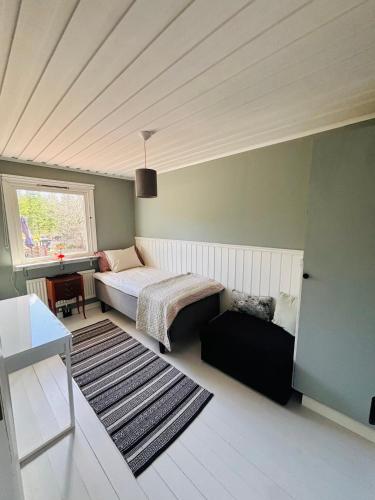 a bedroom with a bed and a table and a window at Chilla villa in Leryd