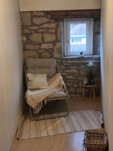 a living room with a chair and a window at La maison de la Loue in Lods