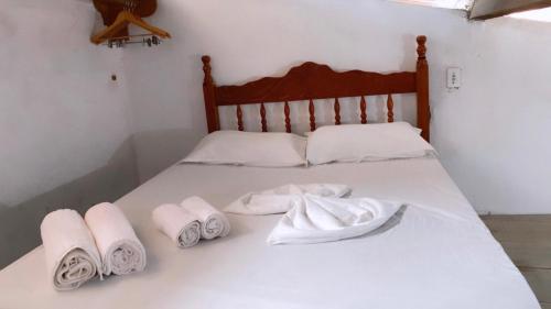 a bed with white towels on it at casa pescador centro in Porto Seguro