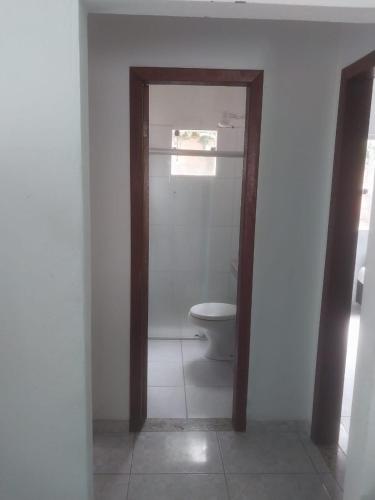 a bathroom with a toilet in a white room at casa pescador centro in Porto Seguro